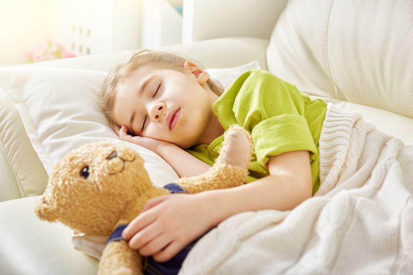 Little girl peacefully sleeping with stuffed bear